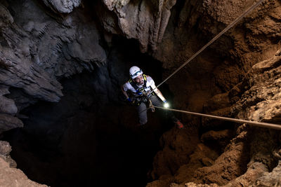 View from above of a man doing caving