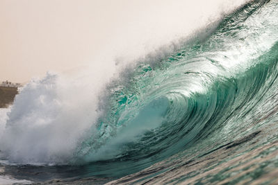 Close-up of water splashing in sea against sky