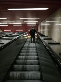 Low angle view of man standing on escalator at subway station