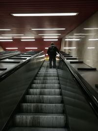 Rear view of woman on escalator