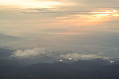 Aerial view of clouds over landscape during sunset