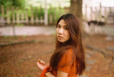 Portrait of young woman standing in park