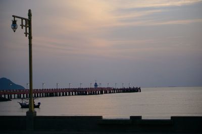 Pier over sea against sky during sunset