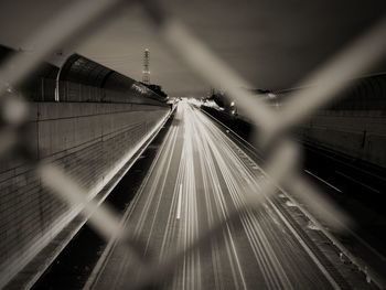 Blurred motion of railroad tracks by chainlink fence