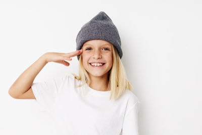 Portrait of young woman wearing hat against white background