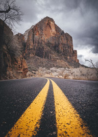 Surface level of road by mountain against sky