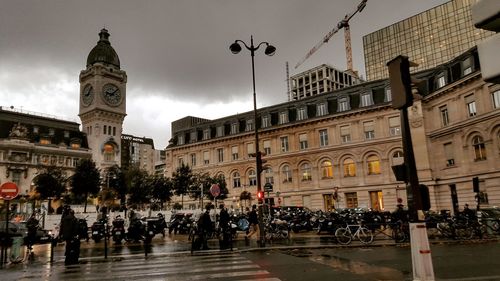 Group of people on street against buildings in city