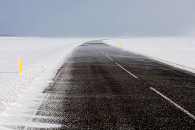 Surface level of road against sky during winter