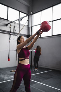 Sportswoman exercising with kettlebell at gym