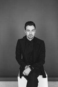 Portrait of young man standing against wall