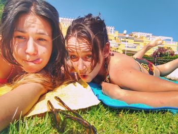 Female friends lying on field in yard