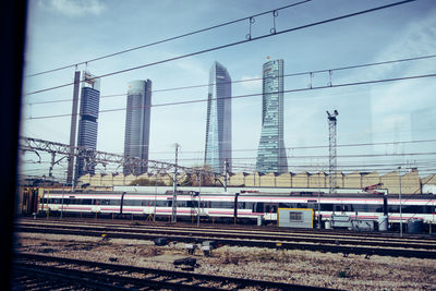 Train on railroad tracks in city against sky