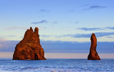 Rock formation in sea against sky