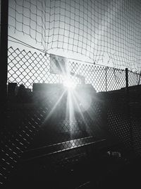 View of chainlink fence against bright sun