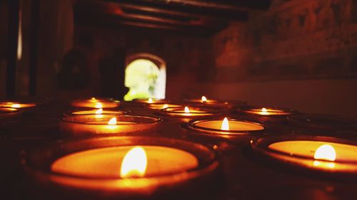 Close-up of illuminated tea light candles in temple