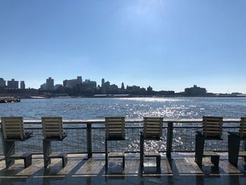 Cityscape by sea against clear sky