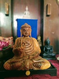 Close-up of buddha statue on table against building