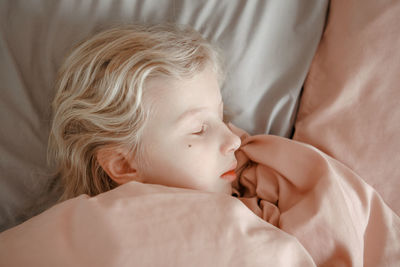 High angle view of baby sleeping on bed at home