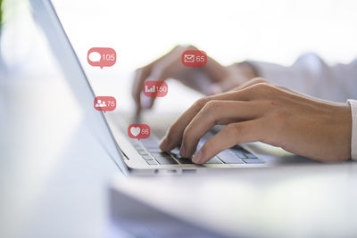 Close-up of man using laptop on table