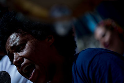 Close-up of man singing on microphone