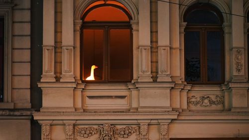 Illuminated lamp against building