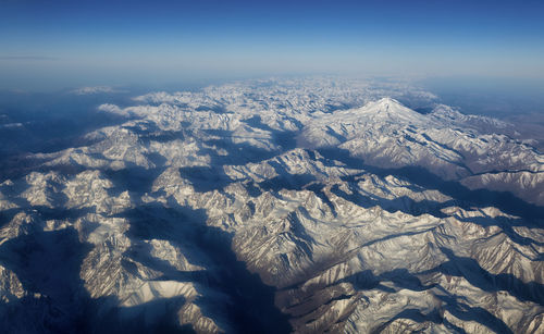 Aerial view of snowcapped mountains against sky