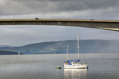 Sailboat on bridge over sea against sky
