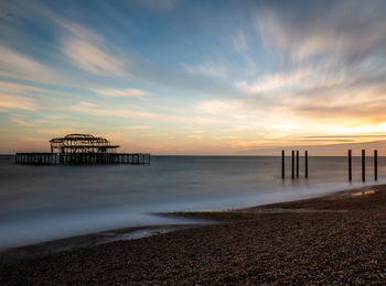 Pier over sea against sky during sunset