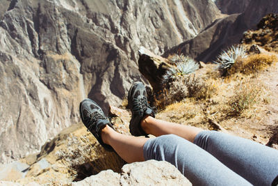 Low section of woman sitting on rock formation