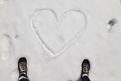 Low section of man standing on heart shape