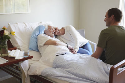 Couple visiting senior man in hospital