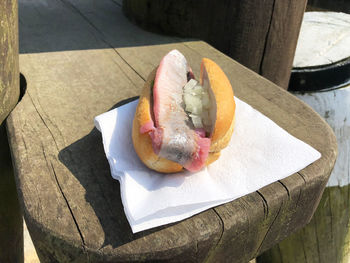 Hot dog with tissue paper on wood