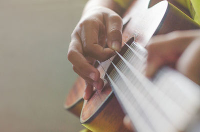 Midsection of man playing guitar