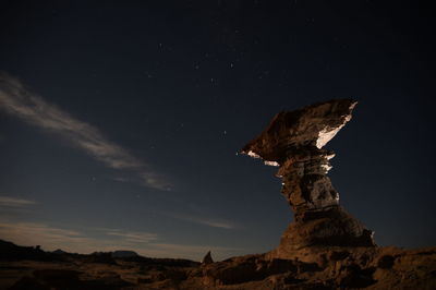 Low angle view of rock formation against sky at night