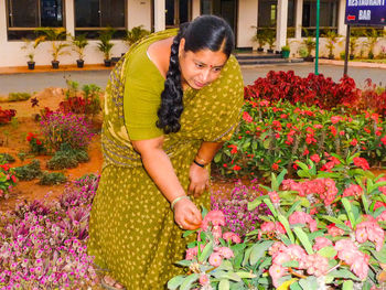 Woman picking flowers blooming in yard