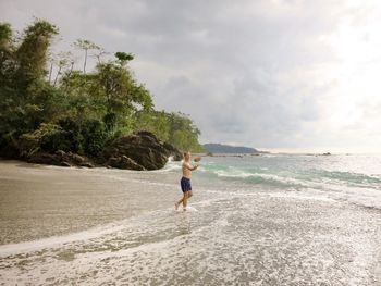 Full length of woman on beach against sky