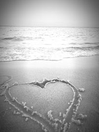 Heart shape on beach against sky