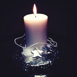 Close-up of lit candle in dark room