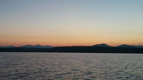 Scenic view of silhouette mountains against clear sky during sunset