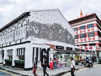 People walking on street against buildings in city