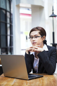 Mid adult man using mobile phone while sitting on table