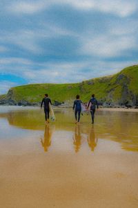 People walking on beach against sky