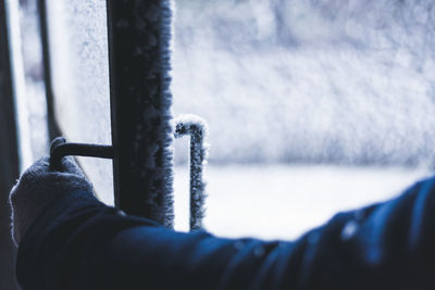 Cropped image of hand holding frozen door