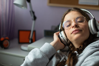 Closed eyes while listening to music on wireless headphones.