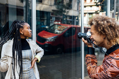 Woman photographing on street in city