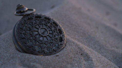 High angle view of pocket watch on sand