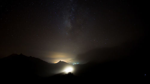 Low angle view of silhouette mountain against sky at night