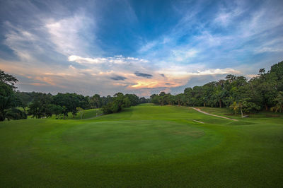 Scenic view of golf course against sky