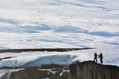 Men standing on snow covered landscape