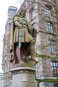 Low angle view of statue against bare trees